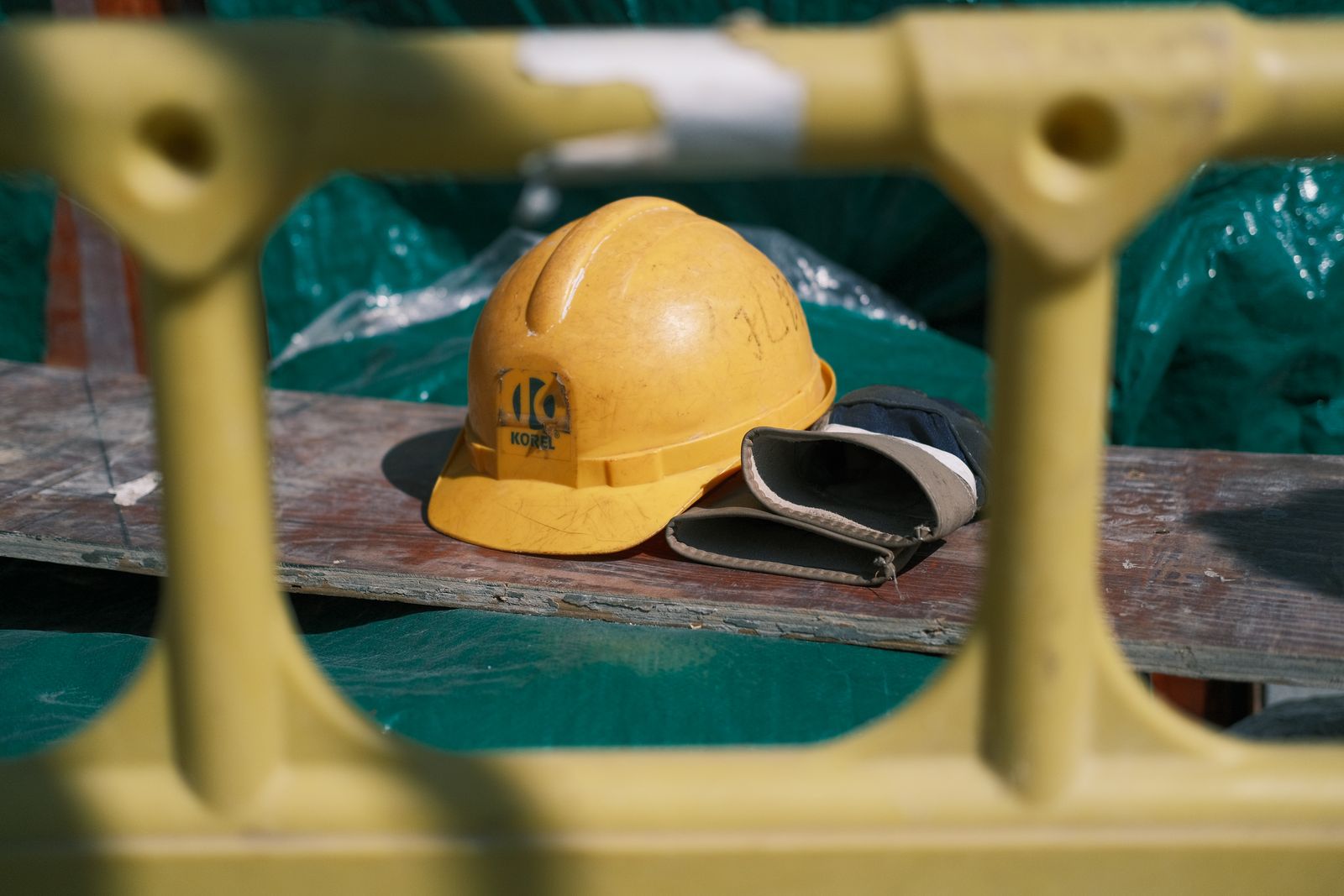Un casque de chantier jaune posé sur une planche d'échafaudage