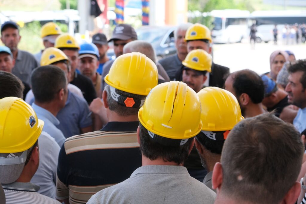 Un groupe de salariés en casques jaunes réunis avant la prise de poste